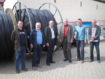 Bürgermeister Henig und Mitarbeiter vor den Breitband-Kabelrollen